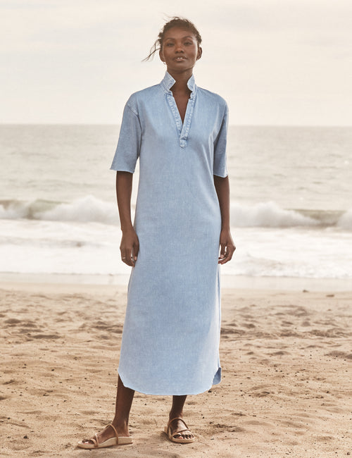Woman wearing a light blue dress on a beach, front view