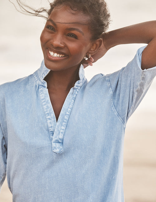 Woman wearing a light blue dress against a neutral background, view 3