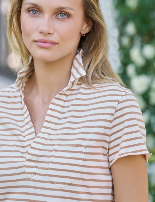 Woman wearing a striped shirt with a blurred green and white background, view 3