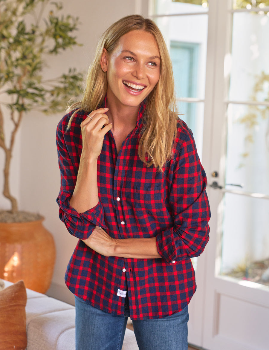 Woman wearing a red and blue plaid shirt in a home setting
