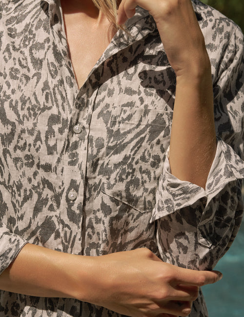 Person wearing a patterned dress with a blurred background, alternate view