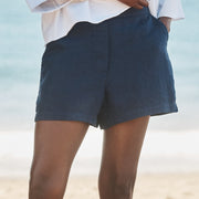 Person wearing navy shorts on a beach