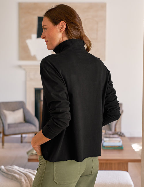 Woman wearing a black shirt in a living room setting, alternate view