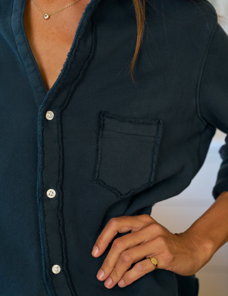 Navy blue shirt with a pocket and button details, worn by a person.
