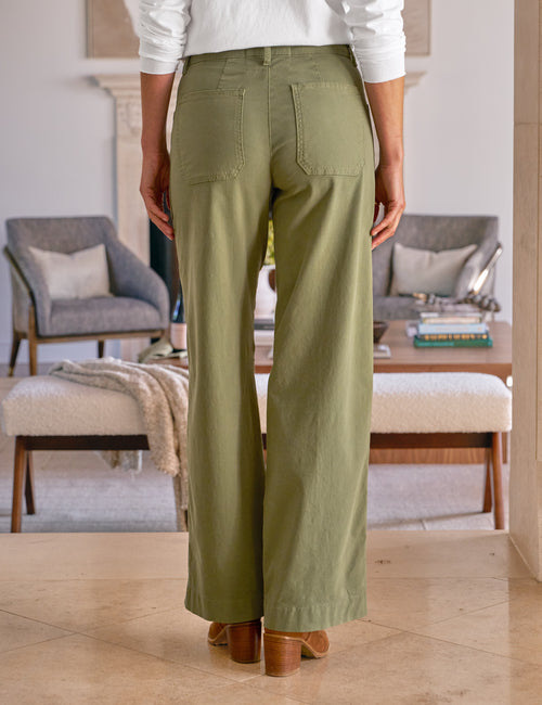 Person wearing olive green pants in a living room setting, alternate view