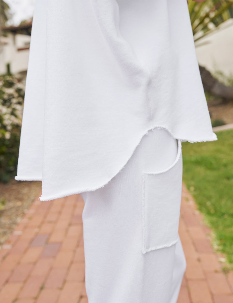 Detail of raw hem edge on person wearing White Frank & Eileen Montauk Travel Set Audrey Capelet and Eamon Sweatpant Jogger in Triple Fleece