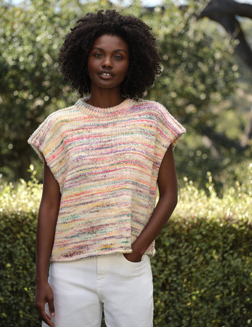 Woman wearing a colorful knitted sleeveless sweater outdoors, front view