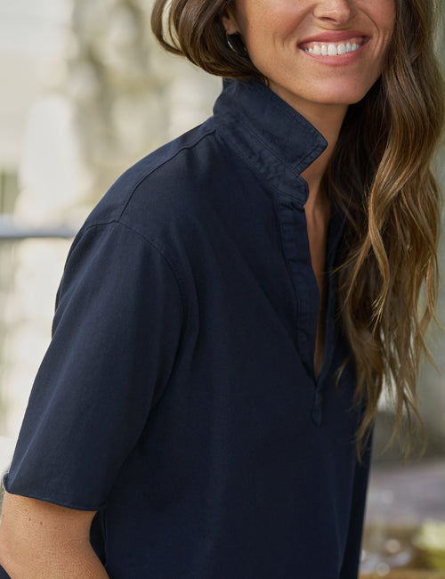 Woman wearing a navy blue shirt with a blurred background, view 3