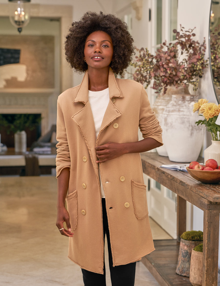 Woman wearing a beige coat in a home setting