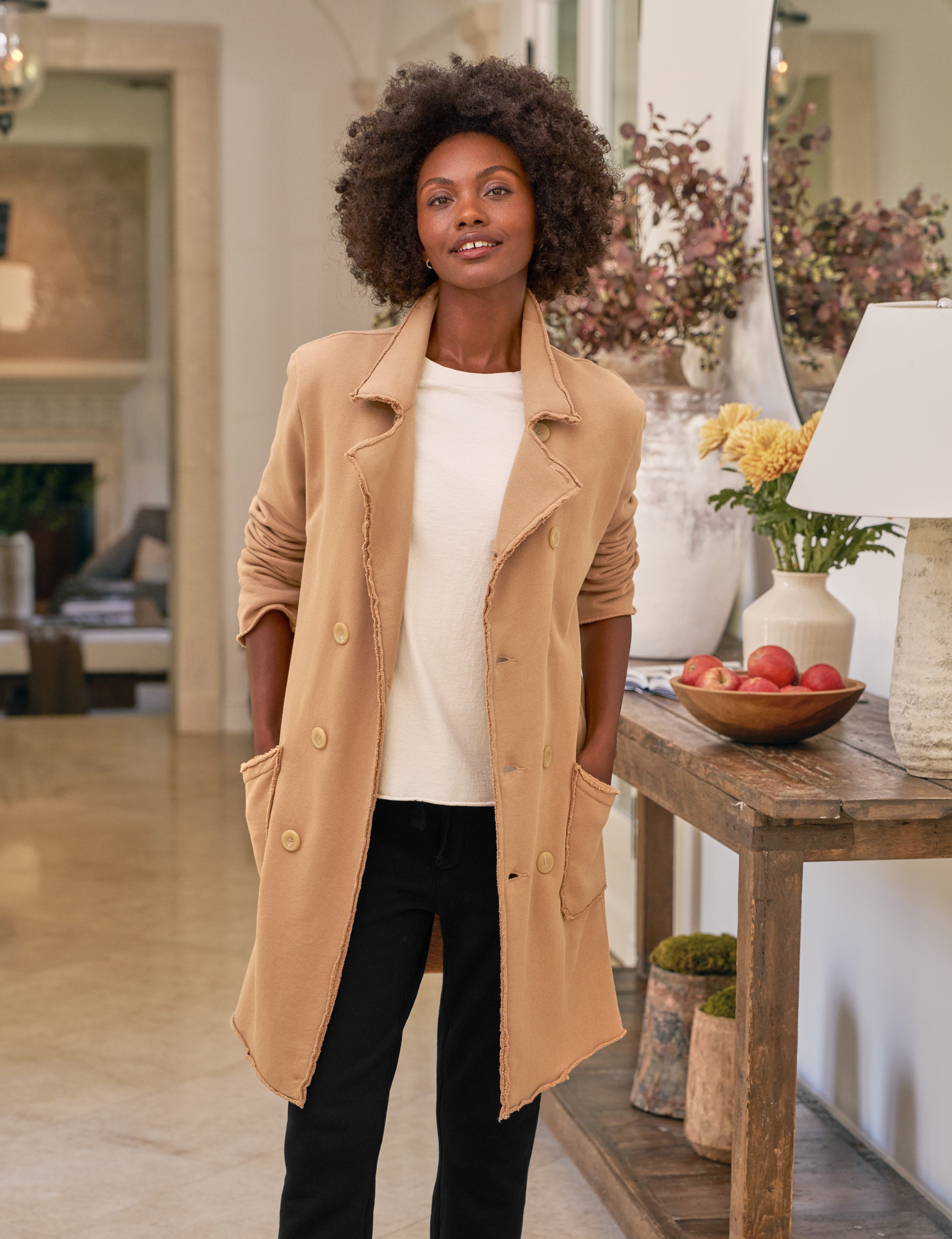 Woman wearing a beige coat in a living room setting