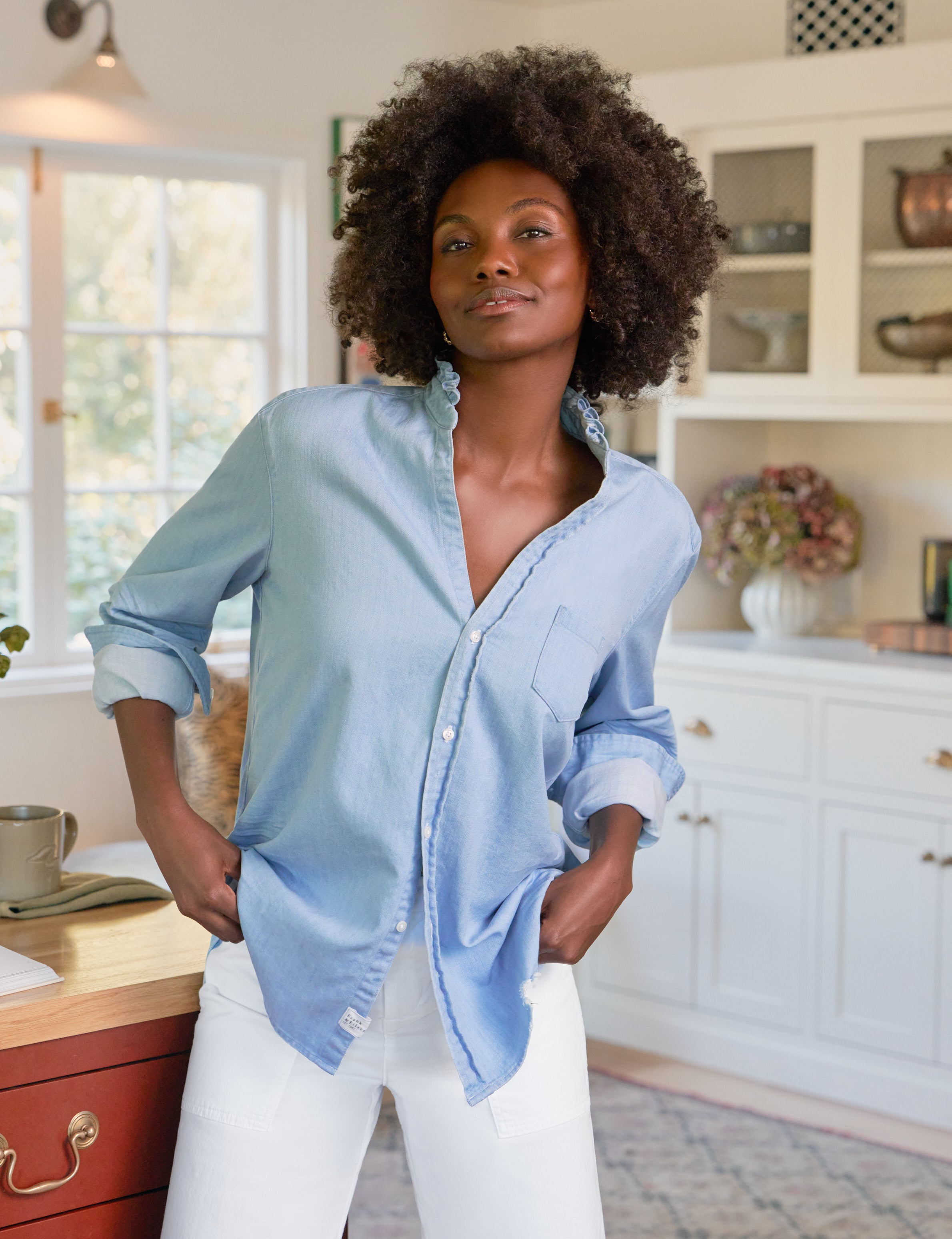 Woman in a blue shirt standing in a kitchen