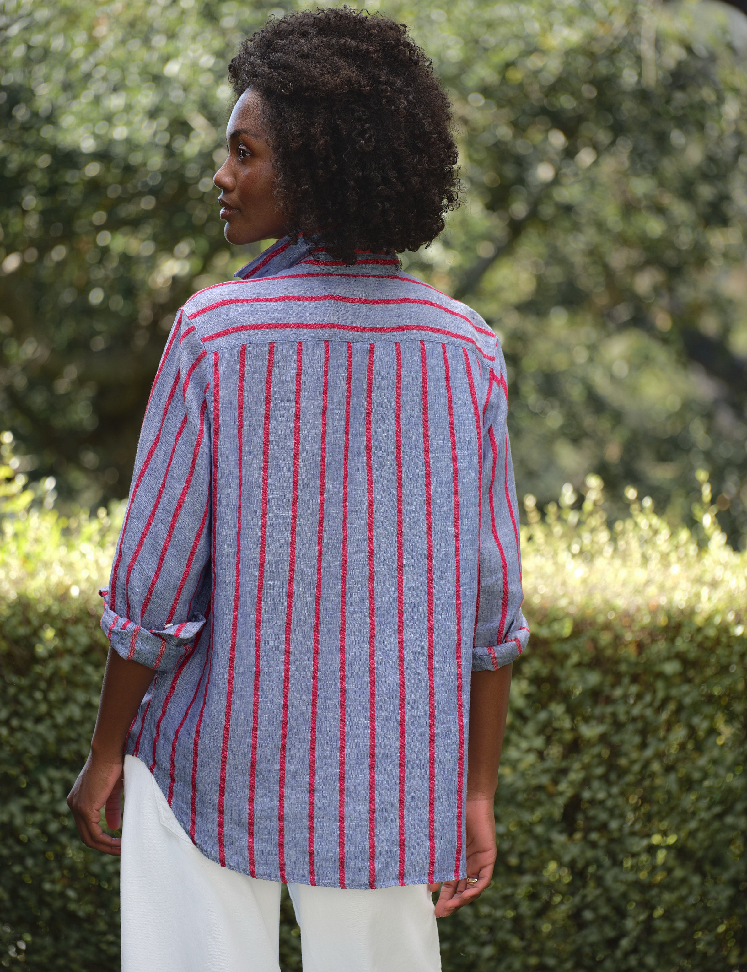 Woman wearing a blue and red striped shirt in an outdoor setting, alternate view