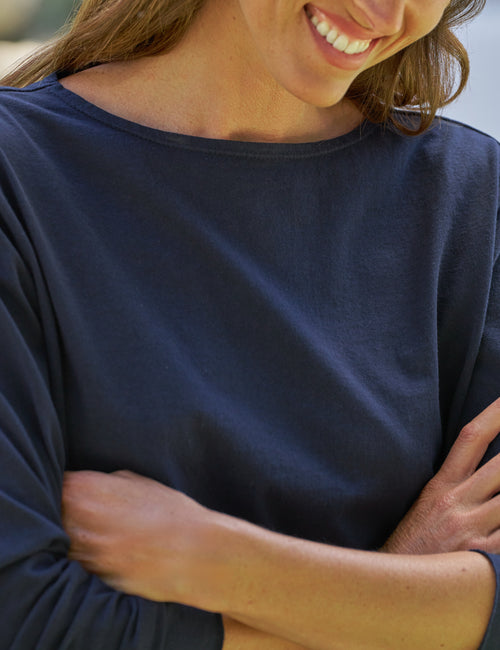 Person wearing a navy blue shirt with arms crossed, view 3