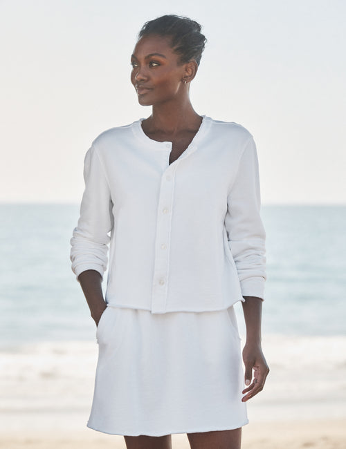 Woman wearing a white outfit on a beach, front view