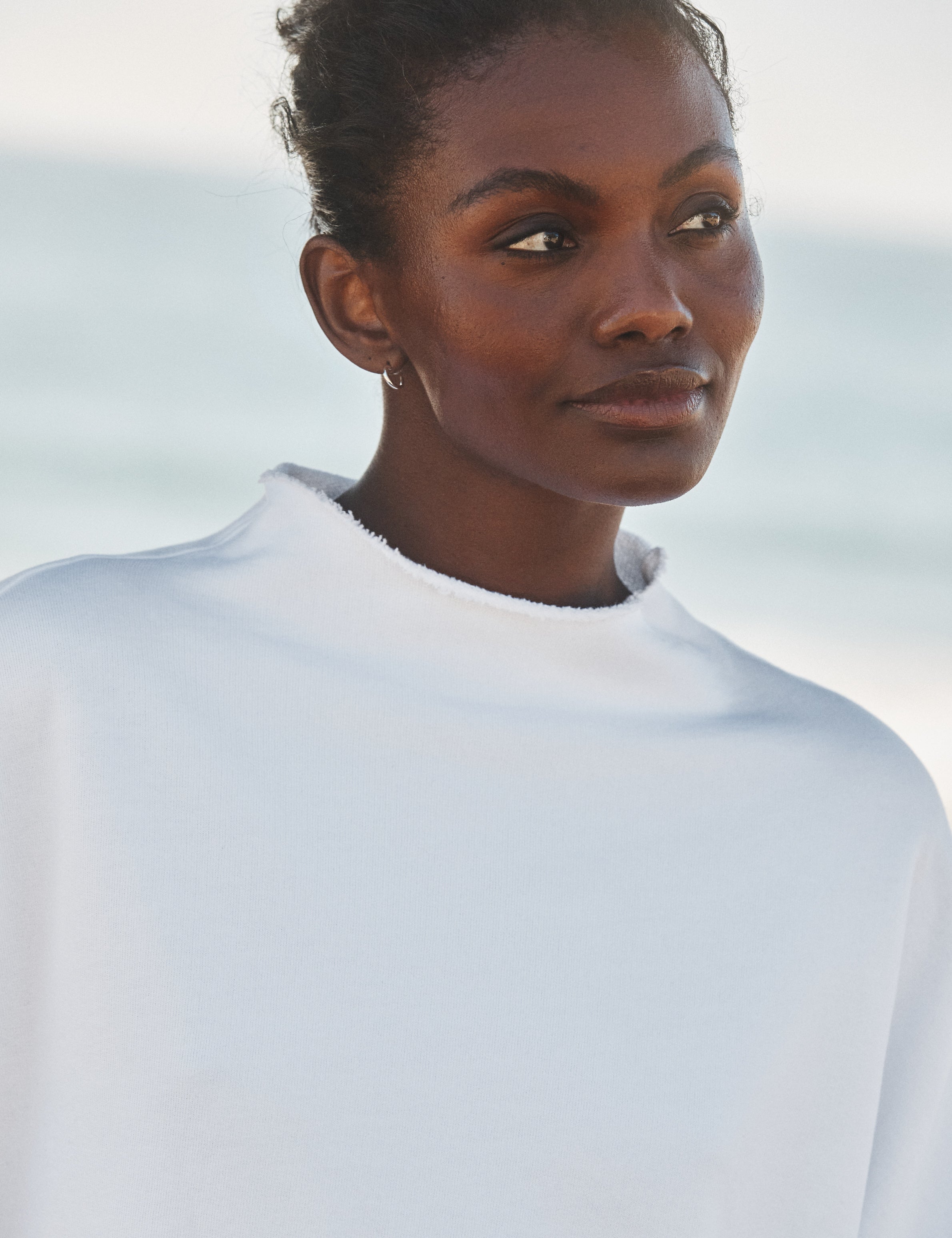 Woman wearing a white shirt against a light background, view 3