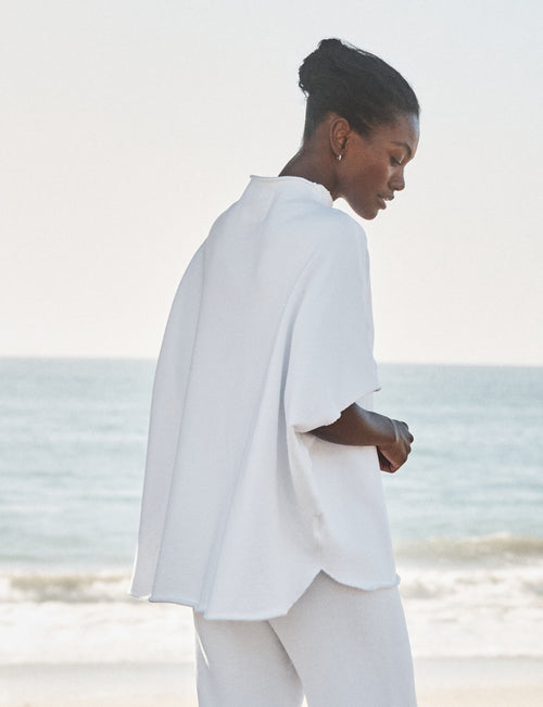 Person wearing a white outfit on a beach, alternate view