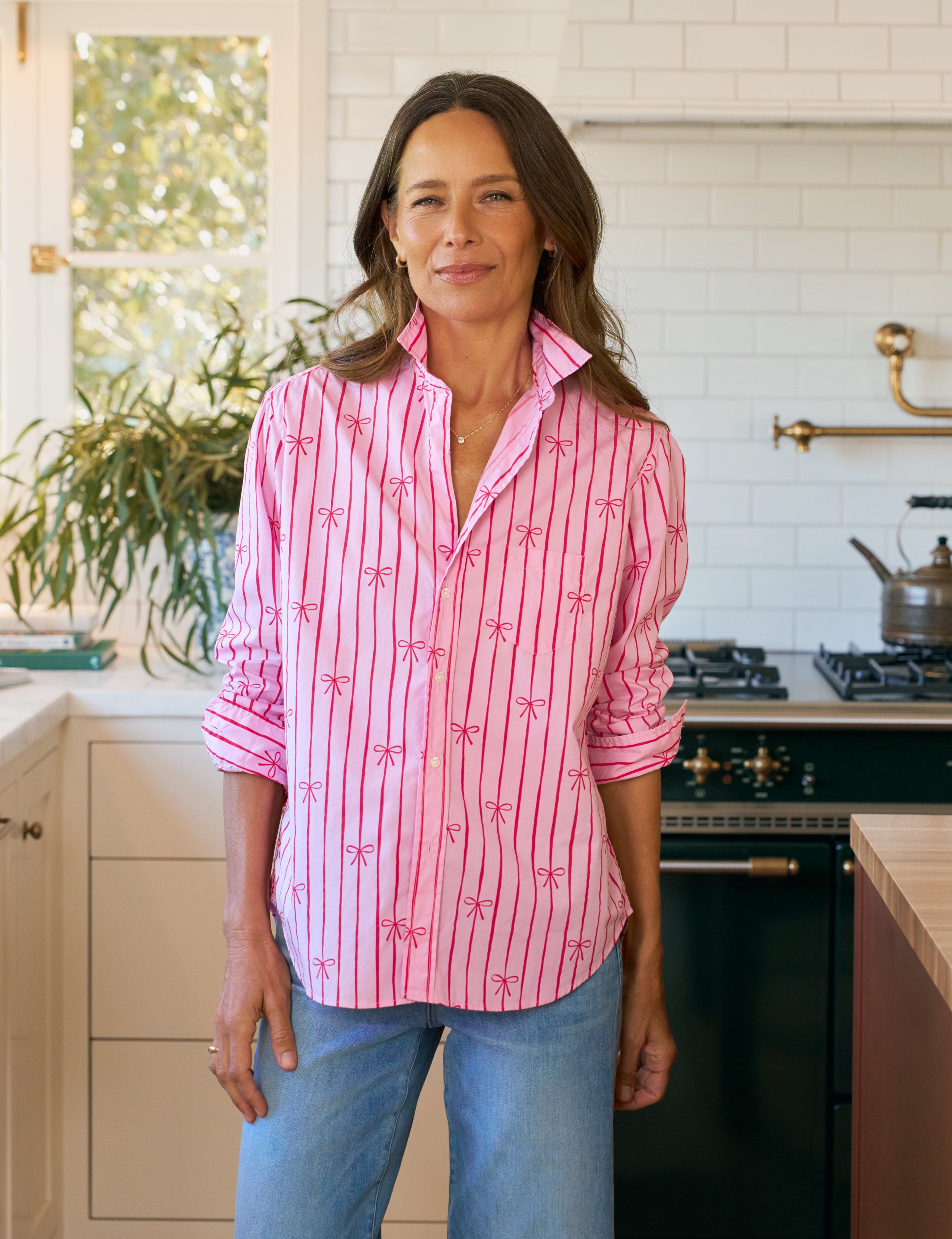 Woman wearing a pink patterned shirt in a kitchen
