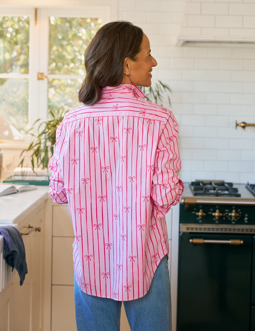 Woman wearing a pink striped shirt in a kitchen, alternate view