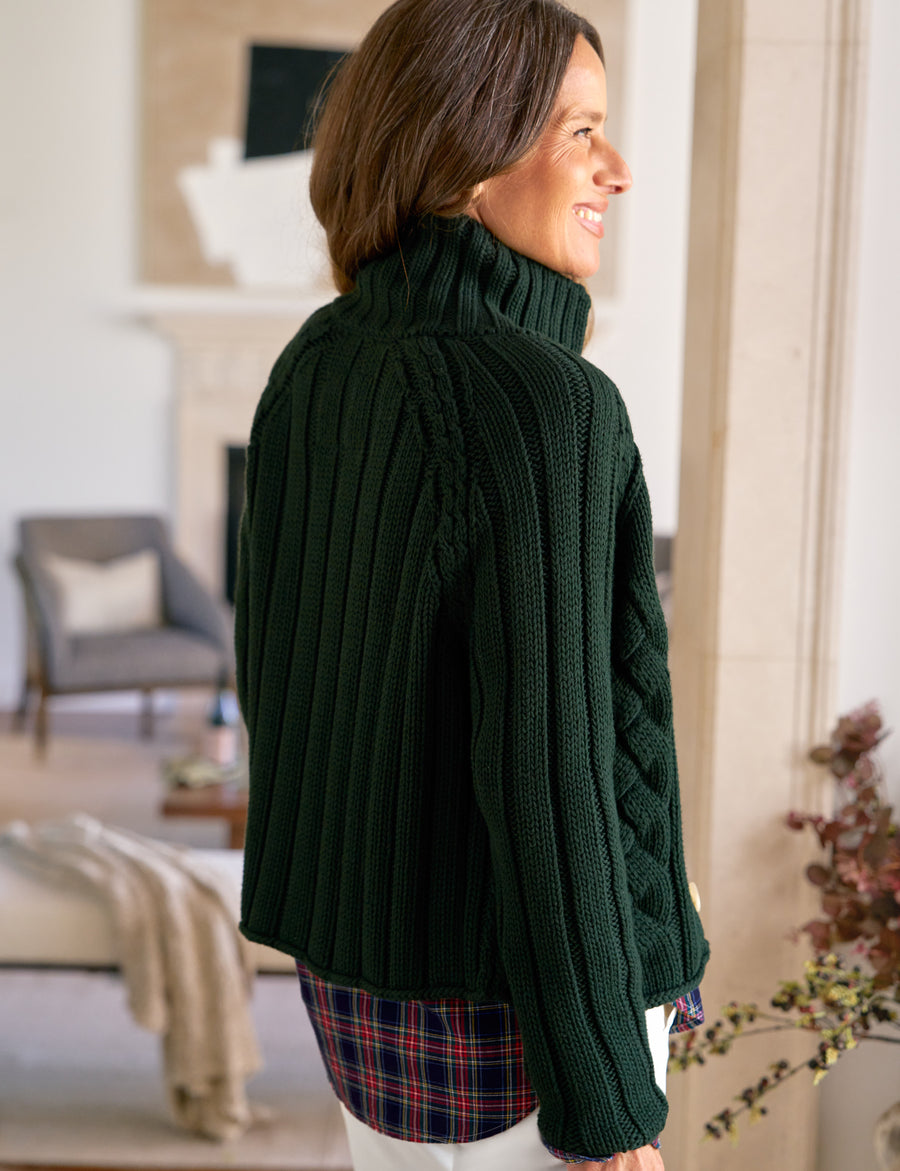 Woman wearing a dark green sweater in a living room setting