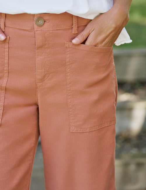 Close-up of terracotta pants with a blurred natural background, view 3