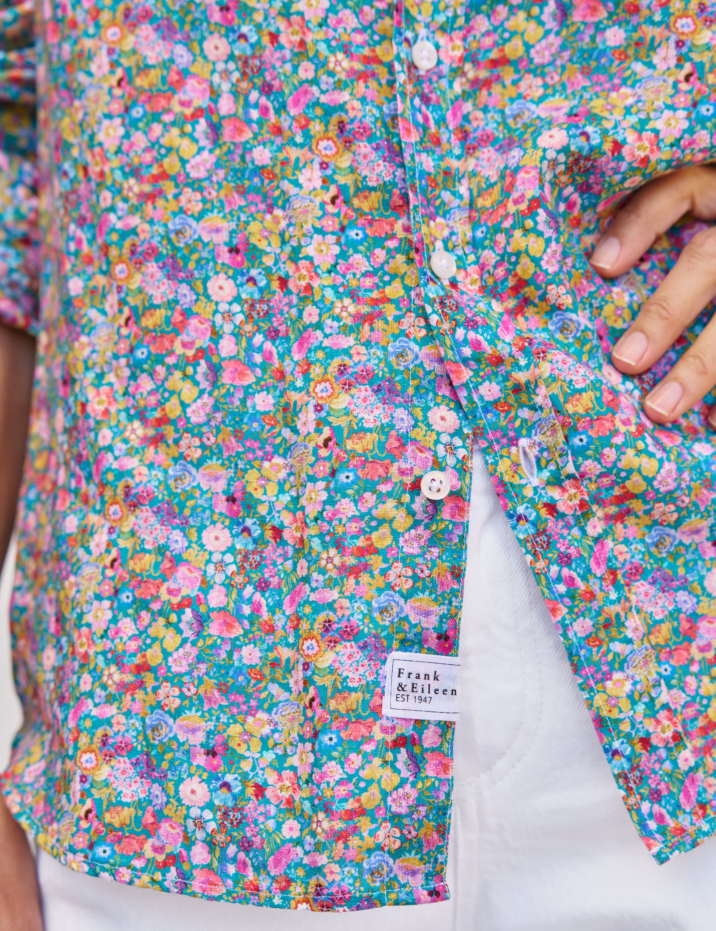Close-up of a colorful floral shirt with a brand label on a white background, view 3