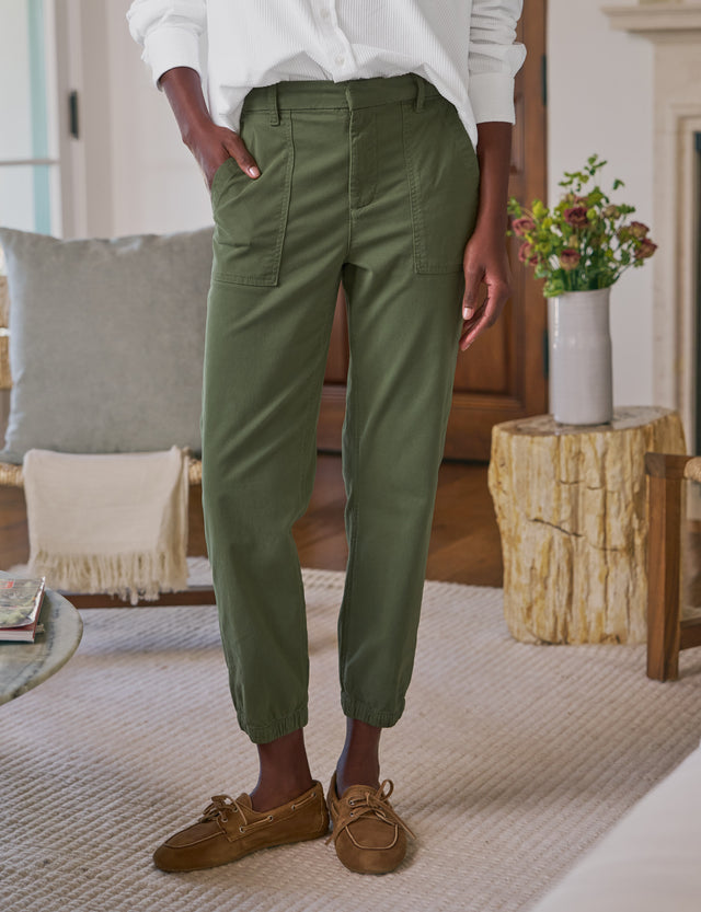 Person wearing green pants and brown shoes in a living room setting