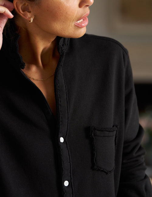 Close-up of a person wearing a black shirt with a blurred background, view 3