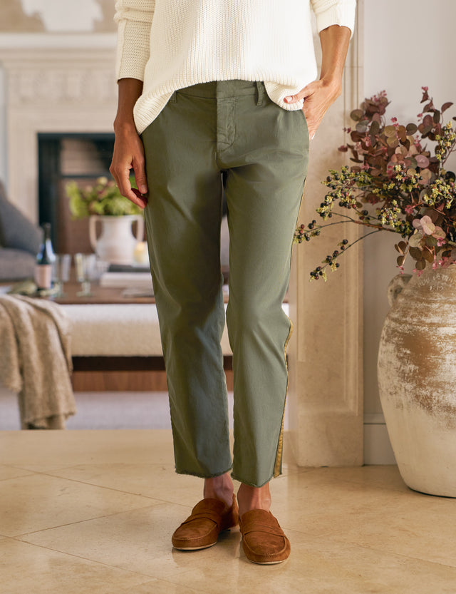 Person wearing green pants and brown shoes in a living room setting