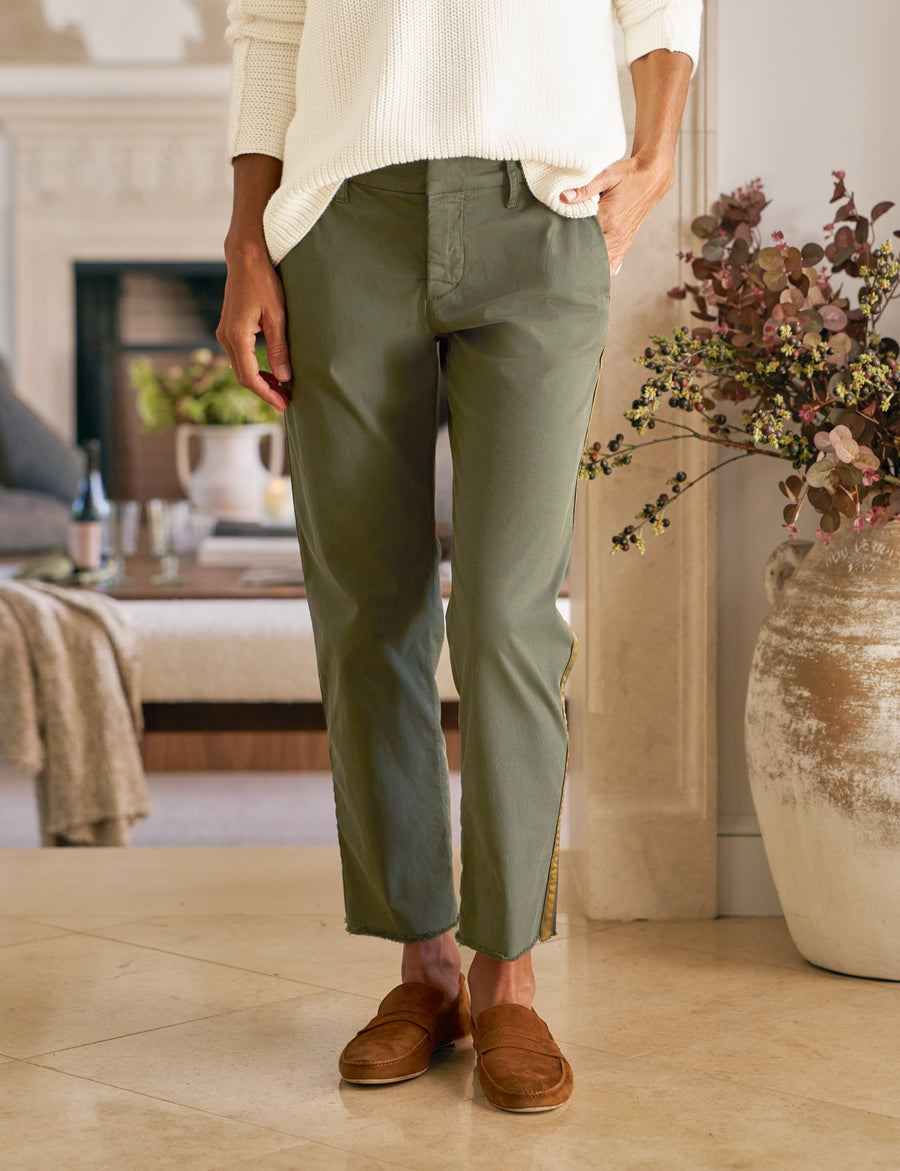 Person wearing green pants and brown shoes in a living room setting