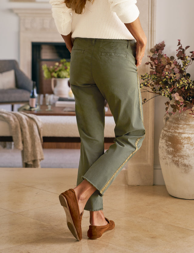 Person wearing green pants and brown shoes in a living room setting