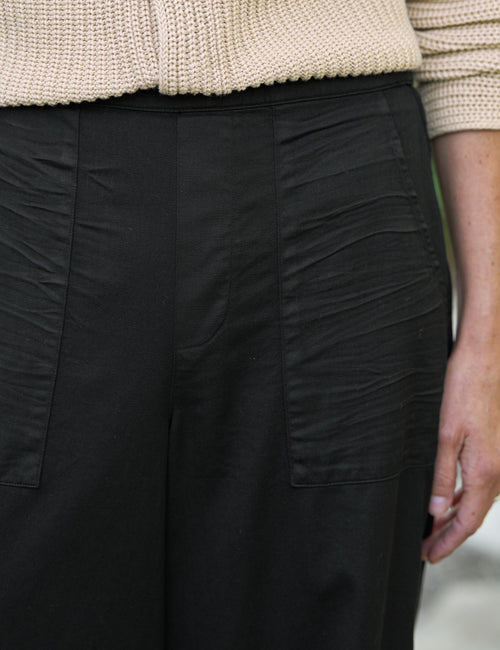 Close-up of black pants worn with a beige sweater., view 3