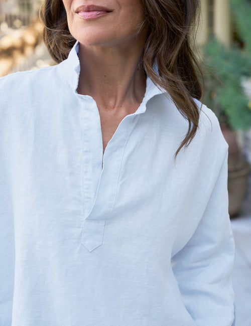 Woman wearing a light blue shirt with a blurred background, view 3