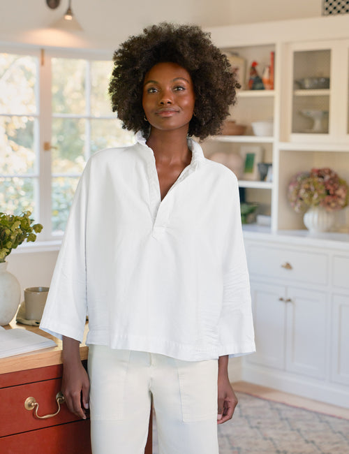 Woman wearing a white blouse in a kitchen setting, front view