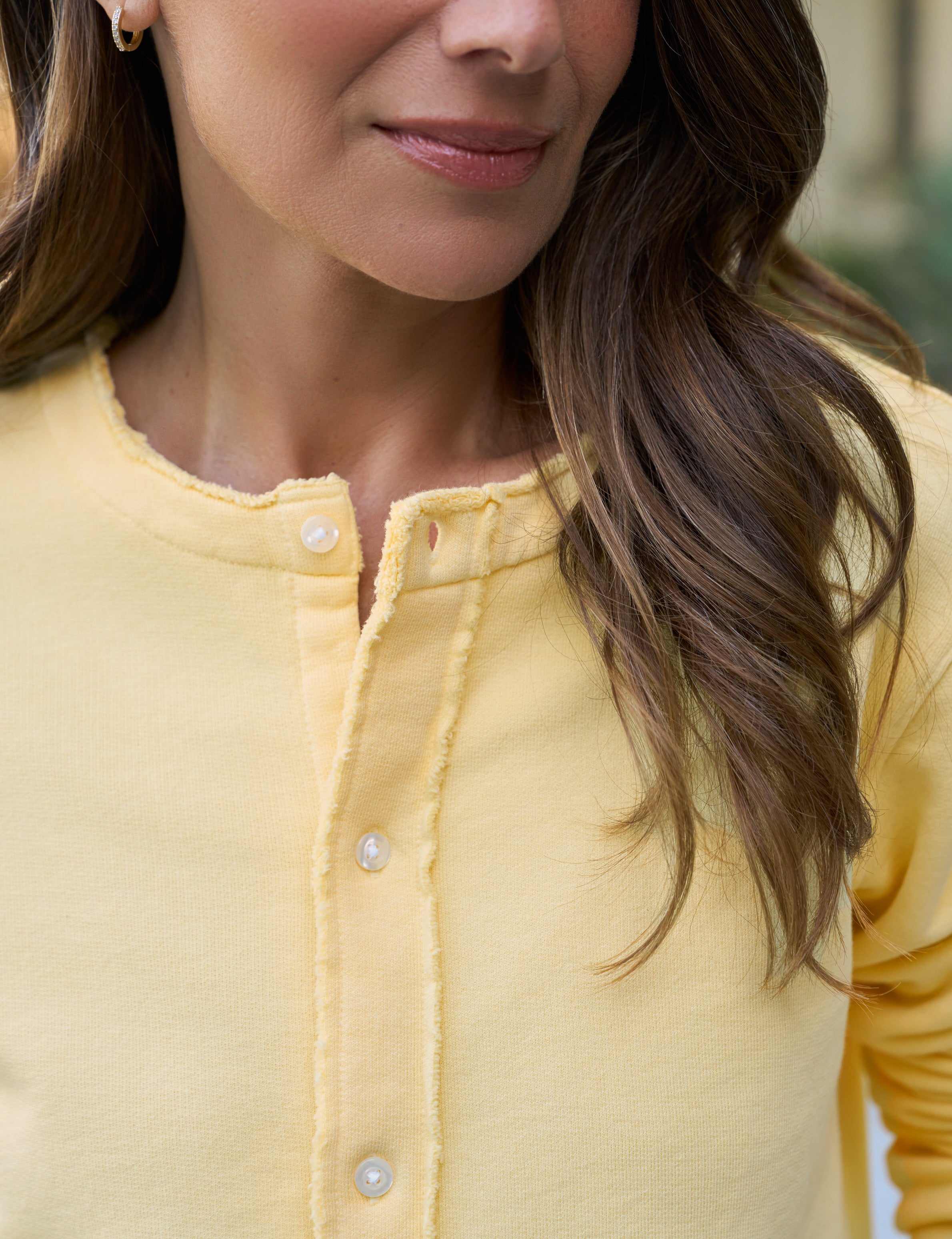 Close-up of a person wearing a yellow jacket with a blurred background
