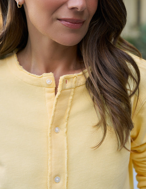 Close-up of a person wearing a yellow jacket with a blurred background, view 3