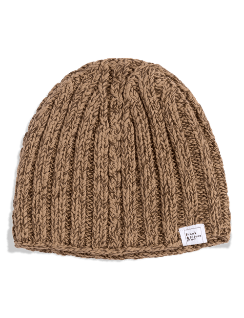 A ribbed knit beanie hat in a warm camel brown color, featuring a small white brand label on the side, photographed against a clean white background., alternate view