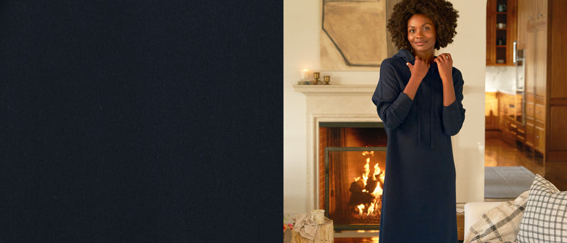 Woman standing in a cozy living room with a fireplace
