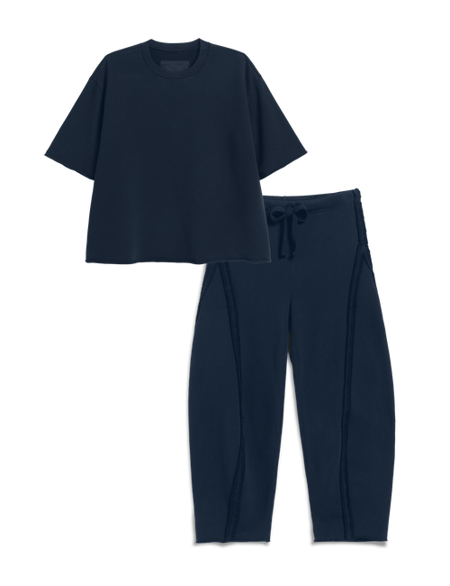 A two-piece navy blue set consisting of a short-sleeve cropped t-shirt and matching drawstring pants, displayed on a clean white background., view 4