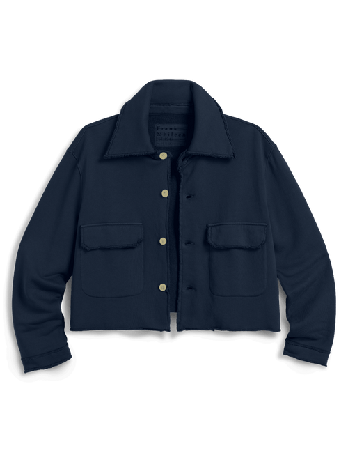 A dark navy blue cropped utility jacket with a pointed collar, button front, and two front flap pockets, shown against a solid green background., view 6