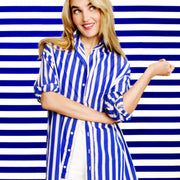 Woman wearing a blue and white striped shirt against a blue and white striped background
