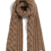 A chunky cable-knit scarf in a warm camel brown color, styled in a loop with the ends hanging down, on a clean white background.