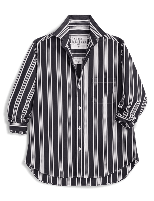 A Frank & Eileen long-sleeve button-up shirt with vertical black and white stripes, displayed against a solid green background., front view