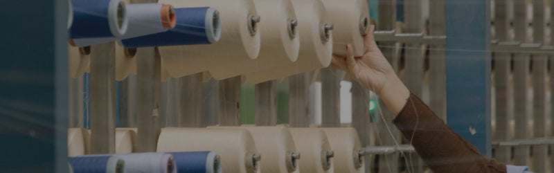 Person handling rolls of paper in a printing or manufacturing setting
