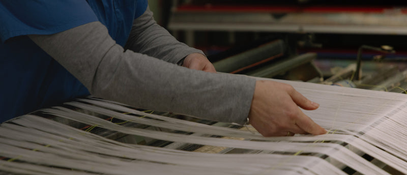 Person working with woven material on a table