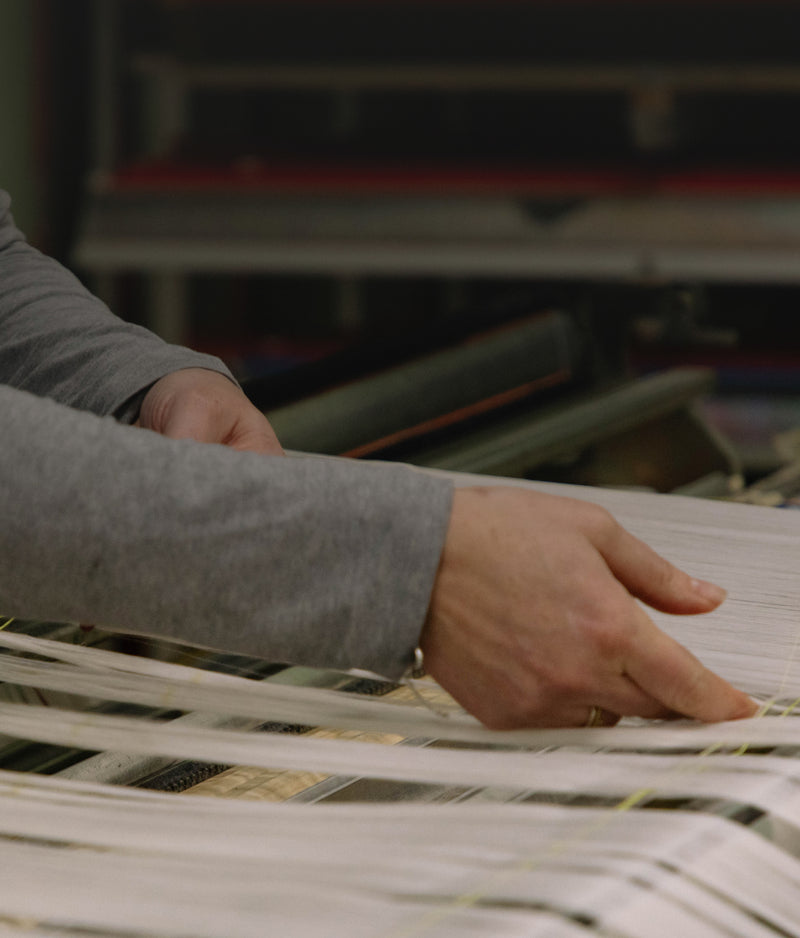 Person sorting through a stack of newspapers with a blurred background